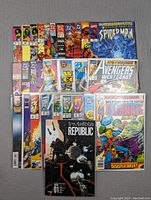 Photo showing 28 comic books laid out, featuring Marvel and DC titles