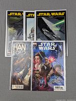 Photo showing 5 Star Wars comic books arranged in two rows; three classic Star Wars comics in the back and Han Solo and Star Wars comics in front.