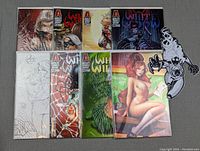 All eight White Widow comic books and one glow in the dark character sticker arranged on surface