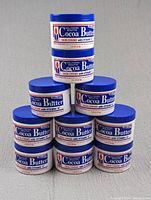 Stacked 10 containers of Hollywood Beauty Cocoa Butter Skin Creme with Vitamin E, showing the product's front label.