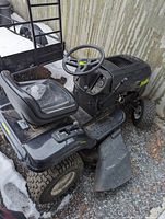 Right-side view showing deck, discharge chute, steering wheel and front tire