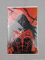 Front cover of Venom #27 Kirkham Virgin Variant comic signed twice, showing the character with chains on red background.