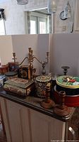 Photo showing all tins, candelabra, candle holders arranged on counter