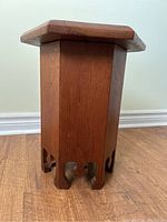 Side view of the wooden hexagonal Moorish style side table showing decorative cutouts at base and warm brown finish.