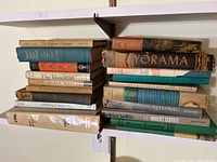 Photo of stacked books showing titles including The Shepherd's Calendar, The Islandman, The Secret Ways, The Wood Engravings of Joan Hassall, The Paid Spike, and others