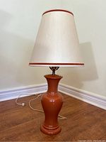 Full view of vintage brown ceramic lamp with white lampshade featuring brown trim, showing the entire item.