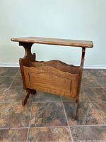 Front view of vintage oak end table with magazine rack showing the rectangular wooden top and two-section magazine rack below.