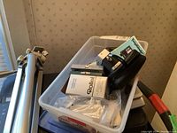 Plastic storage bin containing camera, lens boxes, filters, case and manuals