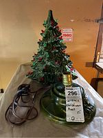 Full view of ceramic Christmas tree with light socket base and power cord, showing green textured tree with red and green bulbs.