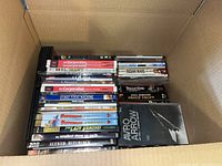 Box top view showing stack of various DVDs with visible titles including The Corporation, Fast Food Nation, Alfred Hitchcock, Avro Arrow.