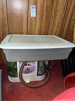 Bissell Little Green cleaner unit partially under a plastic bin