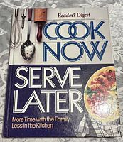Photo of the front cover of the hardcover cookbook titled 'Cook Now Serve Later' by Reader's Digest showing the book's appearance and condition.
