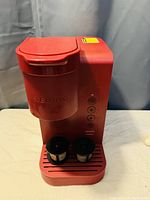 Front view of the red Keurig coffee machine with two reusable coffee filters on the drip tray.