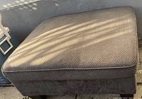 View showing large brown fabric ottoman with textured upholstery and low platform base.