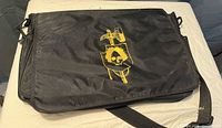 Closed view of the shoulder strap organizer bag showing the yellow graphic on the flap cover.