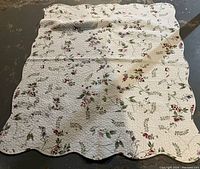 Top view of vintage floral throw blanket showing overall pattern and scalloped edges