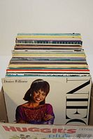 Large stack of vinyl records, showing album spine titles including Art Garfunkel Breakaway and Deniece Williams cover.