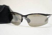 Close-up of Bolle Contour EN166F wraparound sunglasses with gray polarized lenses and black frame on white background.