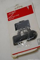 Front view of JOBY GripTight ONE Mount in original packaging showing the holder device inside a sealed plastic package, with red and white branding.