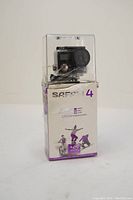 Safari 4 action camera inside clear plastic waterproof case on top of damaged original box.