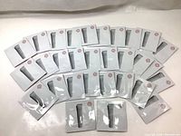 Overview of all 30 individual sealed sample packets of Shiseido Essential Energy Eye Definer arranged on a white surface.