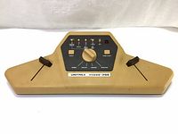 Front view of beige Unitrex Video-Pro console showing entire console shape and layout of controls including joysticks and labeled panel.