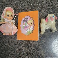 Full view of the Liddle Kiddle Little Bo Peep doll, storybook, and plush sheep arranged on a dark surface