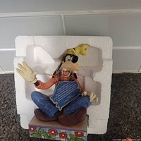 Goofy figurine seated with tag and original styrofoam packaging visible