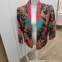 Front view of custom hand-stitched quilted ladies jacket showing floral pattern and quilted red and teal collar textures.