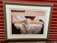 Full view of the framed print showing the reclining nude woman on a bed with white sheets.