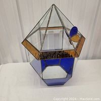 Leaded glass terrarium with clear, blue, and amber stained glass panels and a butterfly decoration visible from the front angle.