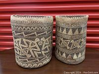 Front view of two traditional Borneo woven baskets side by side on a wooden surface.