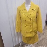 Full front view of the bright canary yellow blazer paired with the skirt on a mannequin.