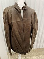 Full front view of chocolate brown leather jacket on mannequin