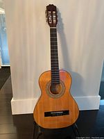 Front view of the 1/2 size Denver acoustic guitar showing natural wood finish and rosette detail around the sound hole.