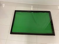Top view of the display case showing black wood frame and green felt inside under plexiglass cover.