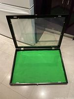 Open display case showing green felt interior and plexiglass top hinged at the back.