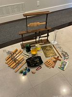 Wide view of all various items including wooden hangers, kitchenware, plaque, sunglasses, paper cutter, ruler, and small items