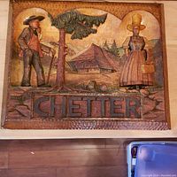 Full frontal view of the solid pinewood carved sign showing the scene, figures, and the carved name 'CHETTER'