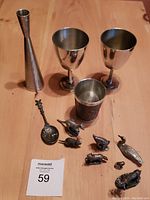 Overall view showing hammered bud vase, two goblets, Celtic mug, animal figures, and anointing spoon