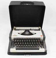 1970's Olympia Traveller Deluxe typewriter in open hard case showing keyboard and overall design.