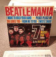 Beatlemania album cover showing title and photos of band members, listing Beatles songs such as 'I Want to Hold Your Hand'