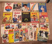 Full lot of 31 vintage Mad Magazines laid out on floor, showing a variety of cover art and special editions.