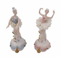 Pair of porcelain ballerina figurines, one with blue bodice and Dresden lace tutu and one with pink bodice and Dresden lace tutu, standing on decorated bases with gold accents.