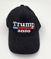 Front view of black baseball hat with Trump 2020 embroidered logo in white, red, and blue.