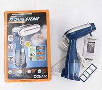Full view of Conair Turbo ExtremeSteam steamer, box, manual, and silicone band attachment on white background