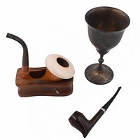 Three items shown on white background: two wooden pipes (one with white ring bowl and wooden holder base) and a tarnished metal goblet with engravings.