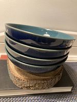 Stack of four blue and green Denby ceramic bowls showing their size and colors.
