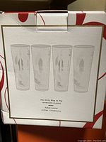 Box of 4 Feather Stemless Champagne Glasses with feather designs and phrases printed in white on the packaging