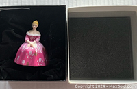 Miniature Royal Doulton figurine in pink floral dress inside box with foam insert.